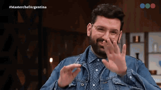a man wearing glasses and a denim jacket is on a television show called master chef argentina