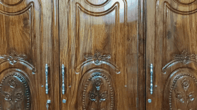 a close up of a wooden door with a carved design