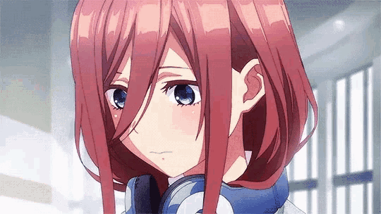 a girl with long red hair and blue eyes is wearing headphones .