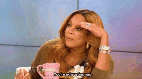 wendy williams is sitting at a table with a pink mug and says you 're exhausting me