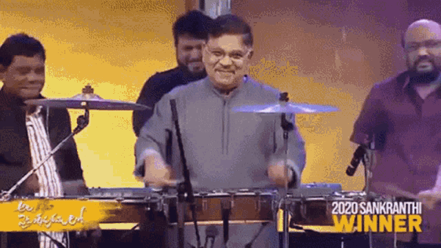 a man is playing drums on a stage in front of a crowd .