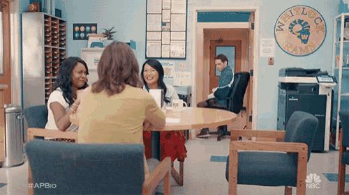 a group of people are sitting around a table in a room with a sign that says minilock rams