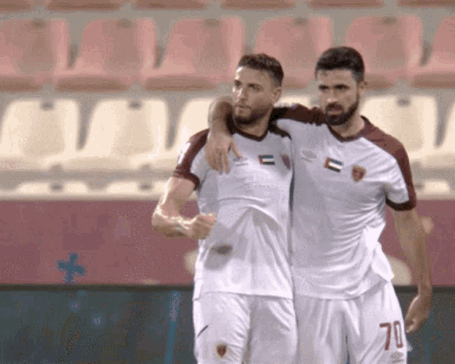 two soccer players one with the number 70 on their shorts