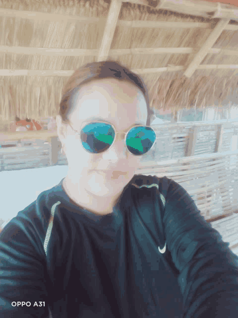 a woman wearing sunglasses is taking a selfie with an oppo a31