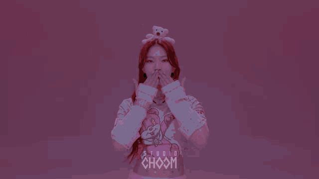 a girl with red hair wearing a teddy bear on her head