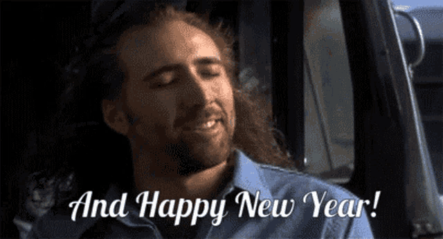 a man with long hair and a beard says " and happy new year " while sitting in a truck