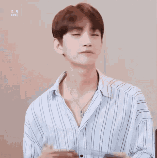 a young man wearing a striped shirt and a necklace has josee written on his shirt