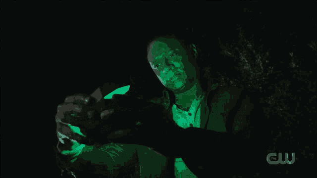 a man in a dark room with a cw logo