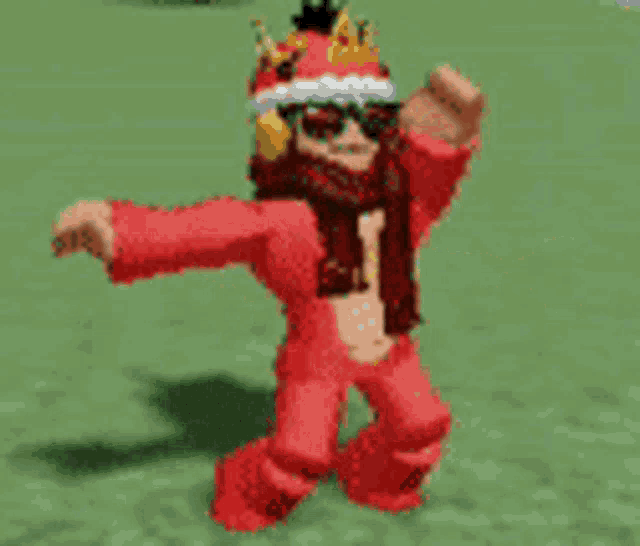 a girl in a red outfit with a crown on her head is standing in a field .