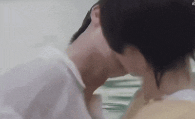a man and a woman are kissing each other in a bathtub .
