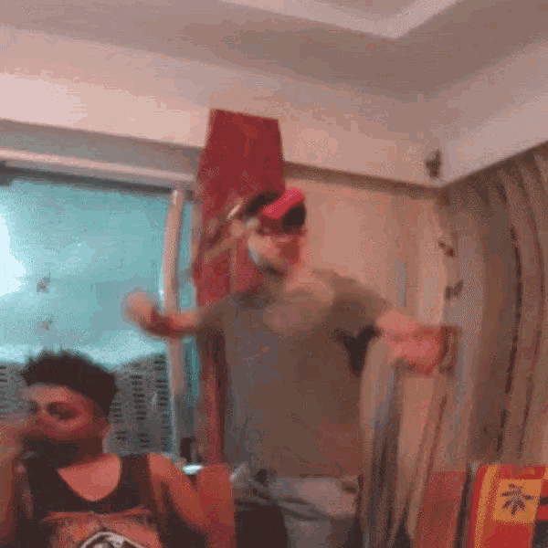 two men are dancing in a room with a chinese symbol on the wall