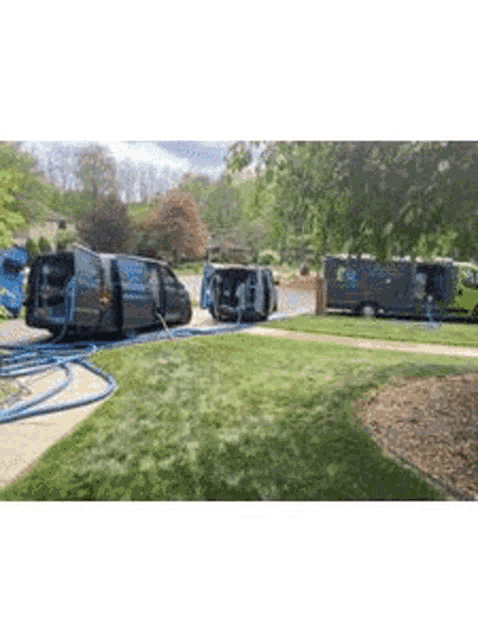 a row of vans are parked in a driveway next to each other .