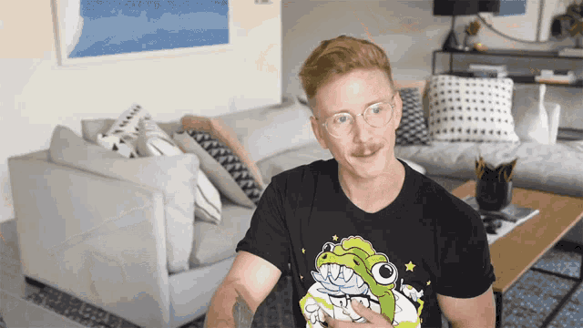 a man wearing a black t-shirt with a cartoon dinosaur on it