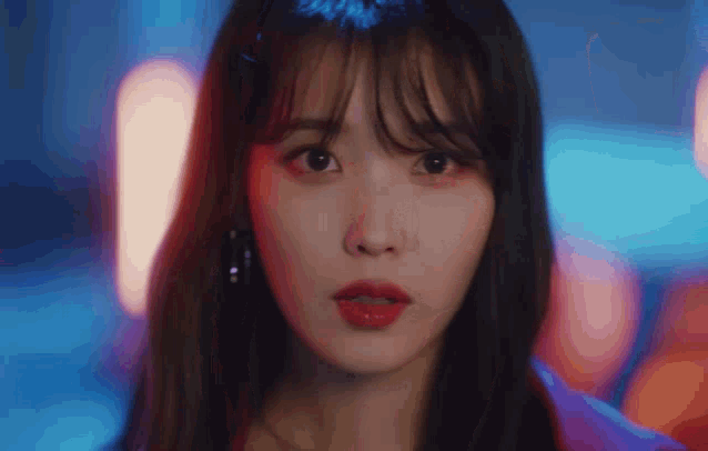 a close up of a woman 's face with red lipstick and bangs .