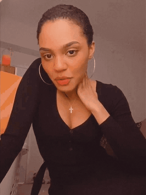 a woman wearing a black shirt and a cross necklace