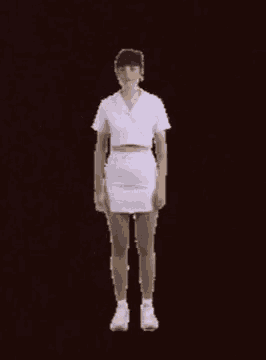 a woman in a white shirt and skirt is dancing with her arms in the air
