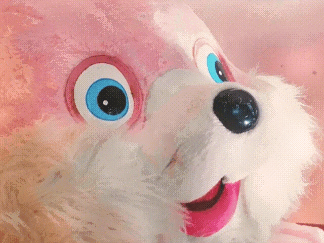 a pink stuffed animal with blue eyes and a pink mouth
