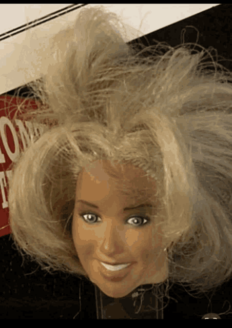 a barbie doll head is smiling in front of a sign that says ' no smoking '