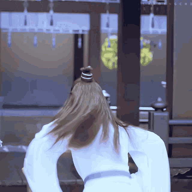 a woman in a ponytail is standing in front of a sign that says " anothingchi "