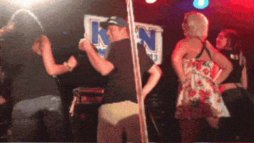 a group of people dancing in front of a sign that says kn on it