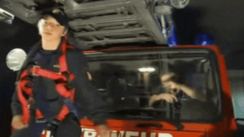 a man standing in front of a red fire truck that says r.w.