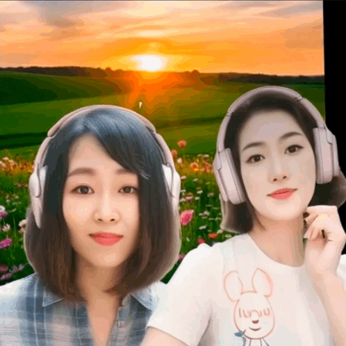 two women wearing headphones are standing in front of a sunset