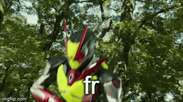 a kamen rider is standing in the woods with trees in the background and the word fr is on the bottom of the image .