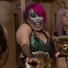 two women are standing in a locker room and one has a wwe logo on her shoulder