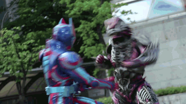 two superheros are fighting each other in front of a building in a city .