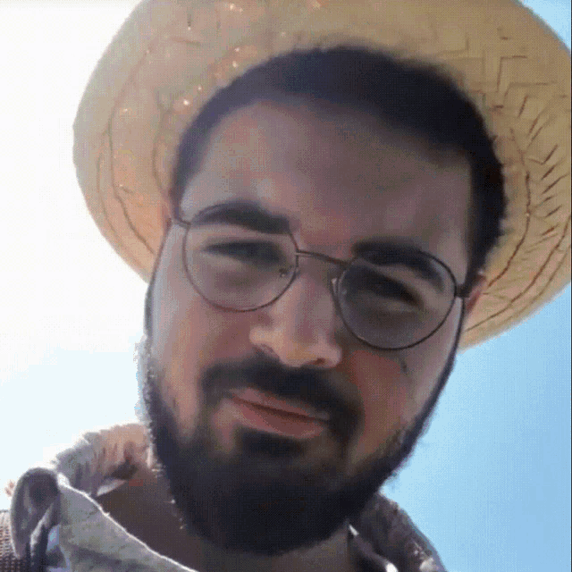 a man with a beard wearing glasses and a hat