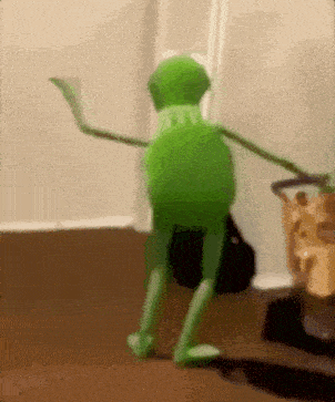 kermit the frog is dancing in a room with a basket of chips in the background