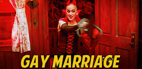a man in a vampire costume is standing in front of a door with the words gay marriage in yellow letters