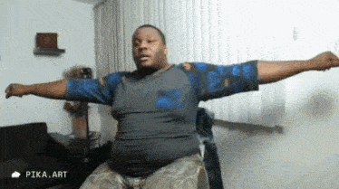 a man is sitting on a chair with his arms outstretched in a living room .