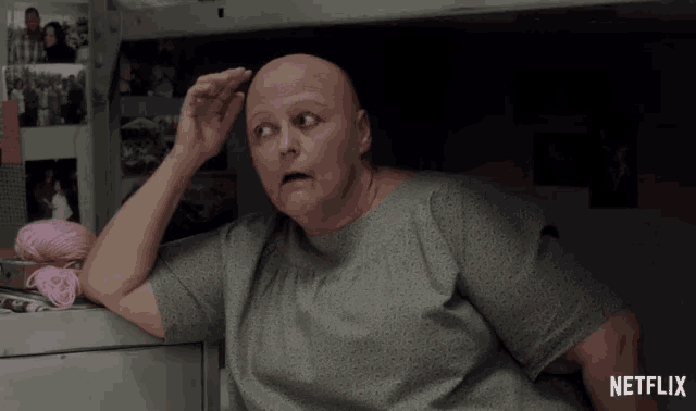 a woman with a bald head is sitting in a netflix room