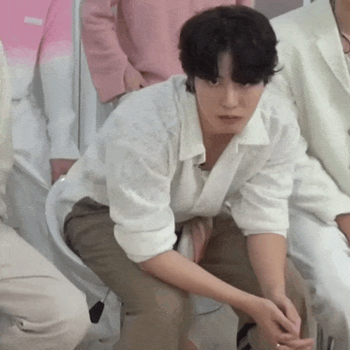 a man in a white shirt is kneeling down