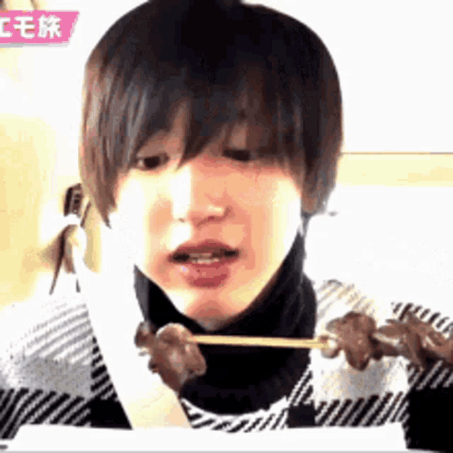 a woman is eating a piece of meat with a toothpick .