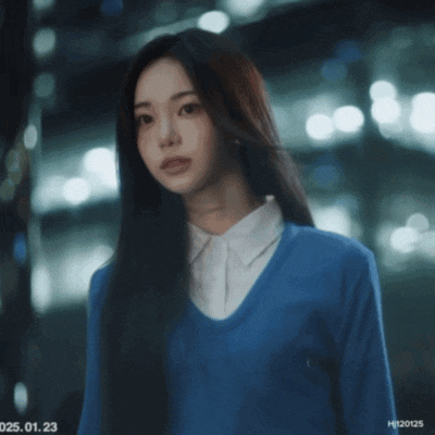 a woman wearing a blue sweater and a white shirt has a date stamp of 025.01.23