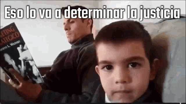 a man is reading a book to a young boy with the words eso lo va a determinar la justicia written above him