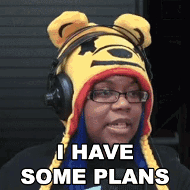 a woman wearing a winnie the pooh hat and headphones is saying i have some plans