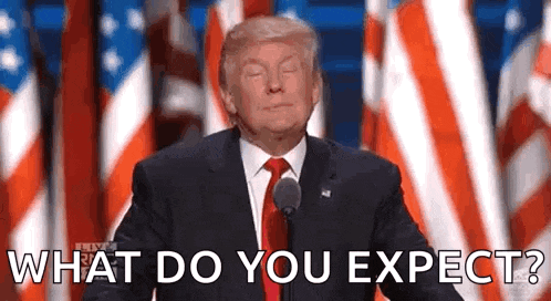 donald trump is giving a speech in front of an american flag and asking what do you expect ?