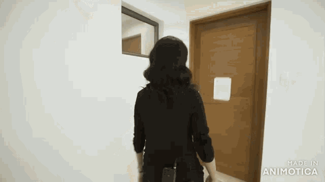 a woman is standing in front of a door that says made in animatica