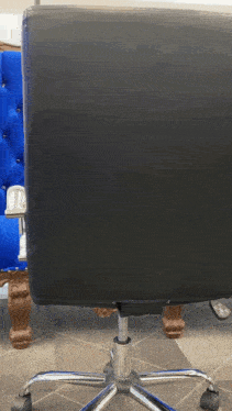 a black office chair is sitting in front of a blue tufted chair