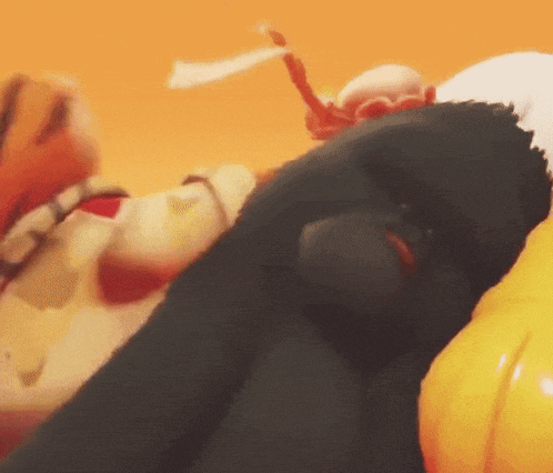 a close up of a stuffed animal laying on top of a pumpkin
