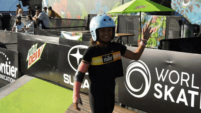 a girl wearing a blue helmet and a nike shirt