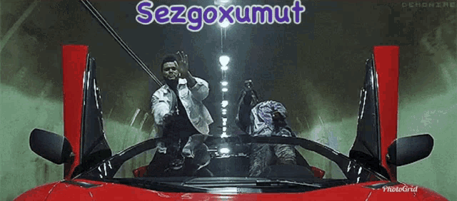 two men are sitting in a red sports car with the words sezgoxumut written on the top