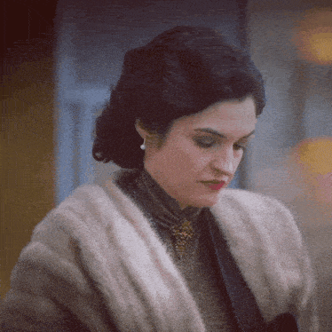 a woman wearing a fur coat and a necklace