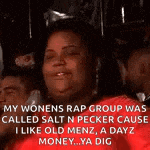 a woman in a red shirt is sitting in a crowd of people with a caption .