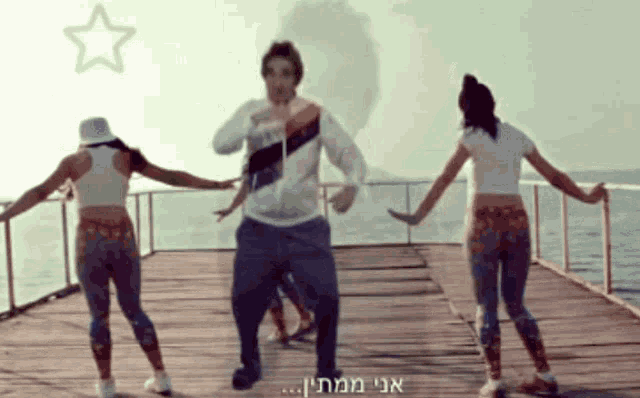a man and two women are dancing on a pier with a star behind them