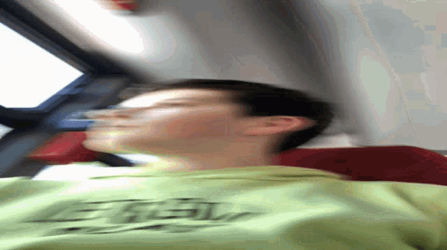 a blurry picture of a person wearing a green shirt that says e.t.v.