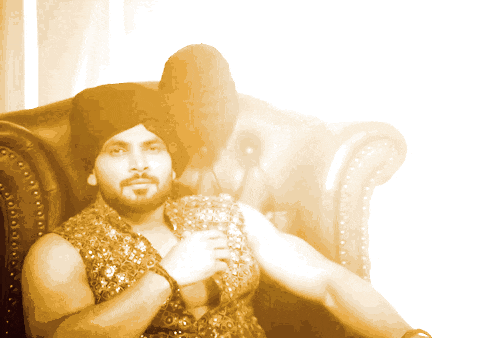 a man in a turban sits in a chair with his arm outstretched